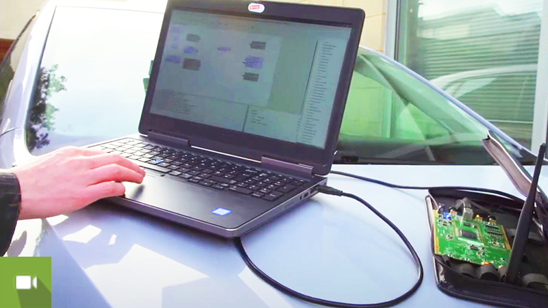 portátil em cima de capô de carro a testar o software